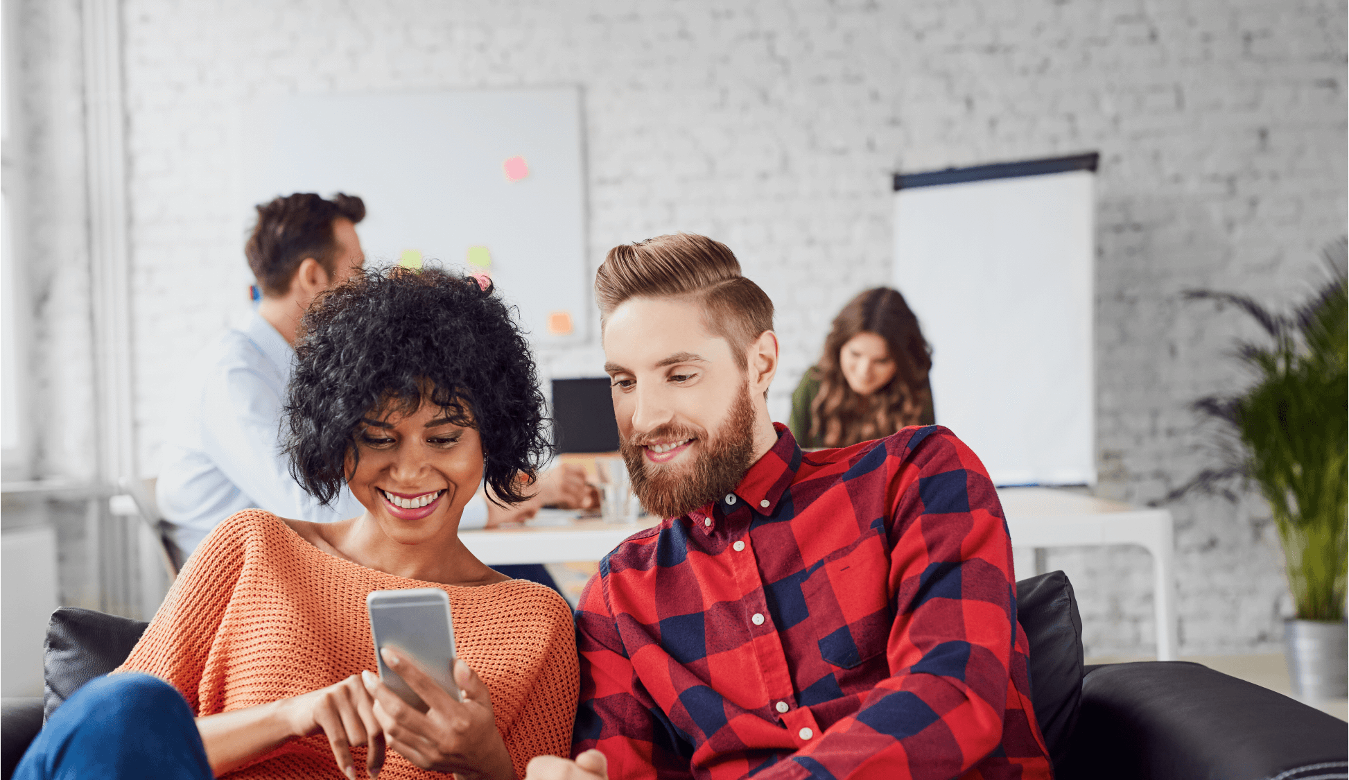 A man and a woman look at a phone screen together